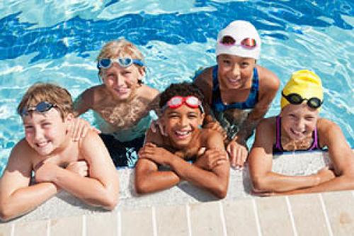 Camp children in outdoor swimming pool. 