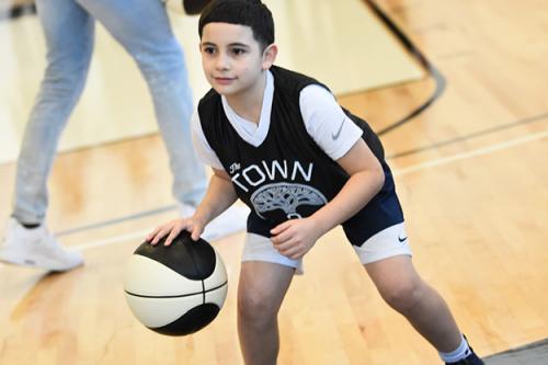 young boy dribbling on oakland court