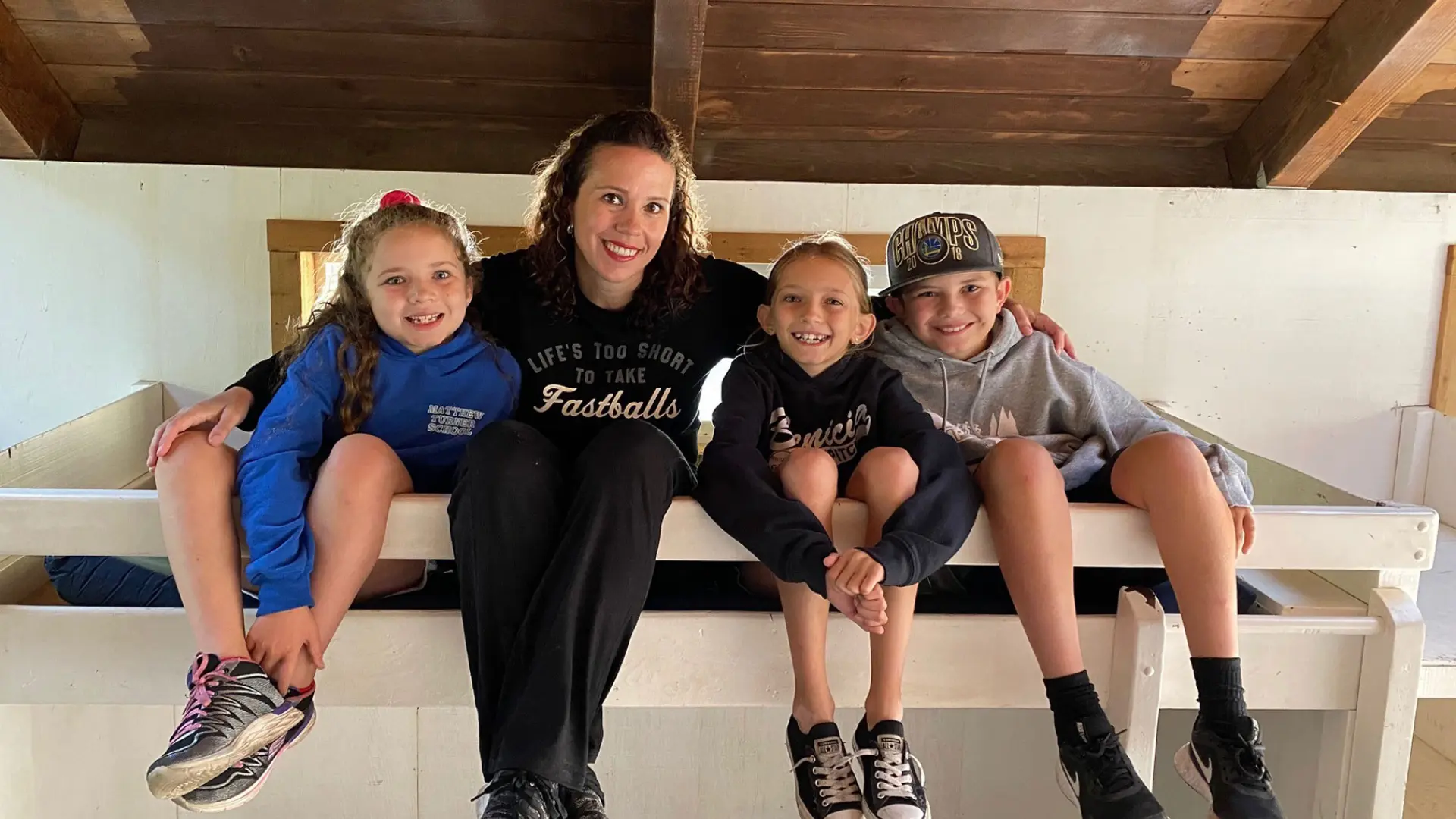 mother with three children sitting on top bunk bed at Camp Loma Mar