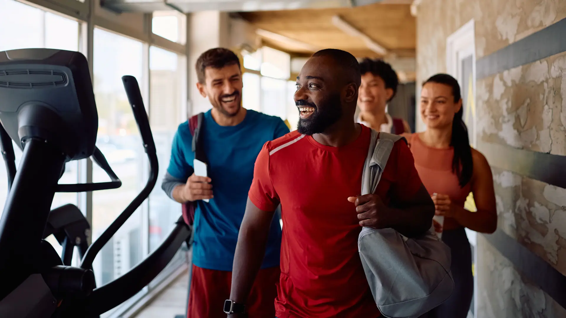 Diverse group of adult members walking out of the cardio room