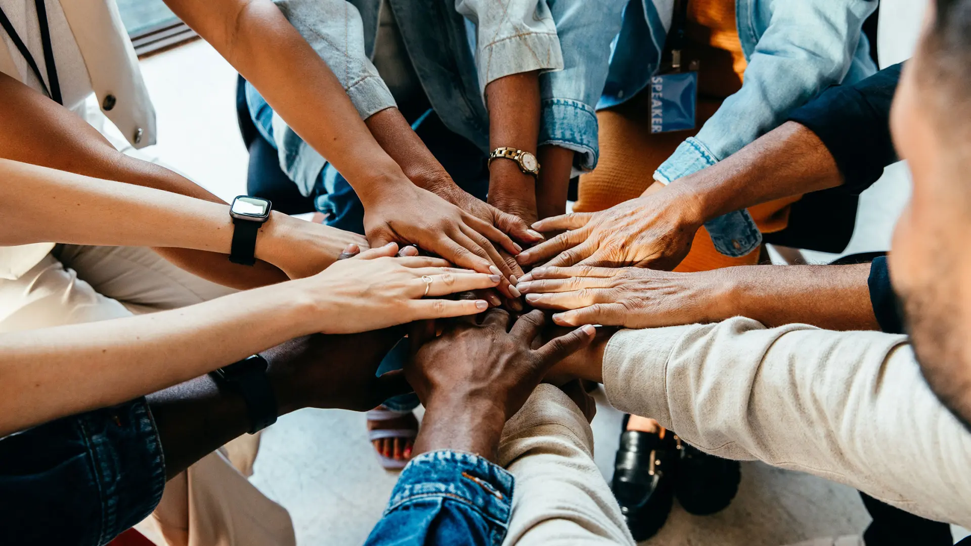 Group of diverse people with all hands in 
