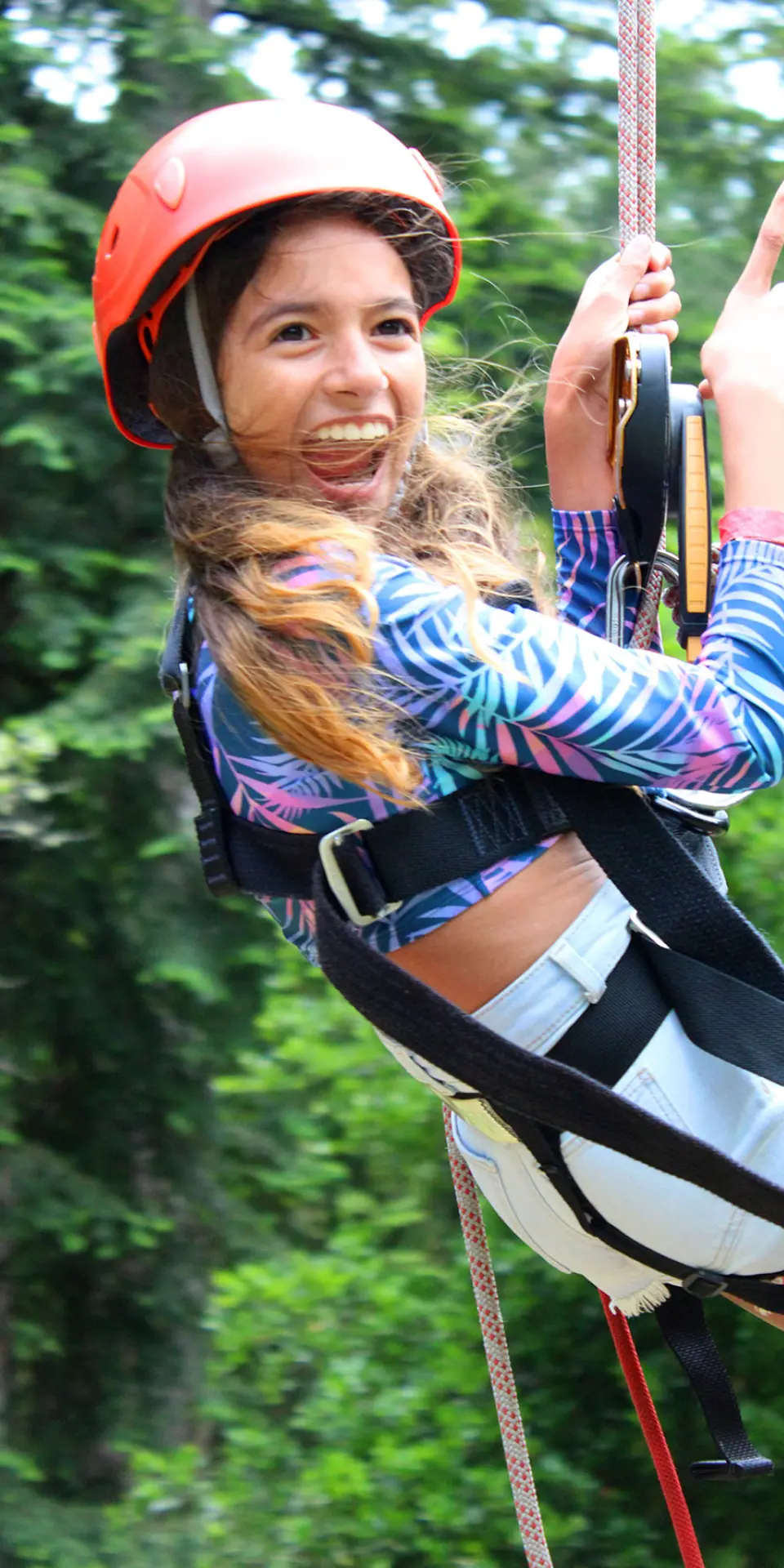 Camp Loma Mar female camper smiling while on the zip line