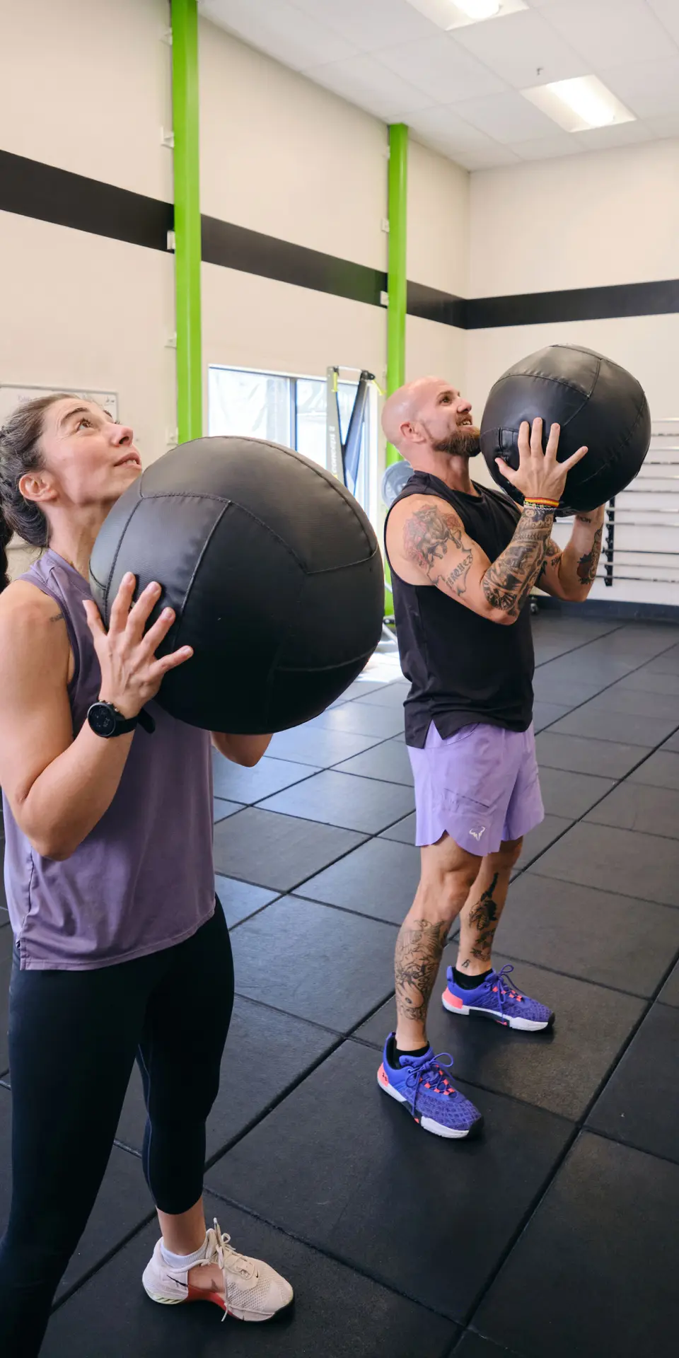 Personal trainer with clients performing medicine ball lifts at the Pleasant Hill YMCA
