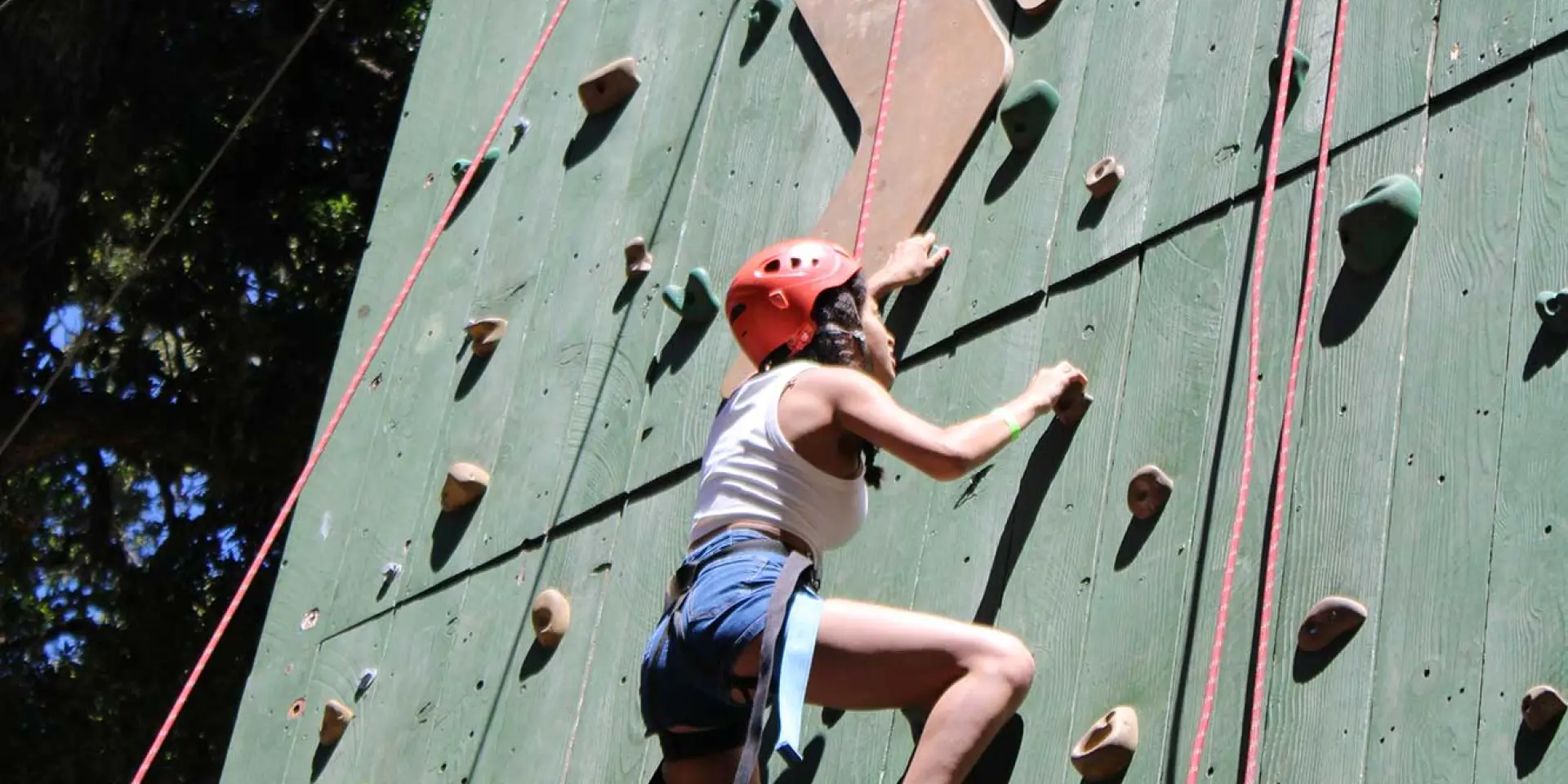 student age female on climbing rock wall at Camp Loma Mar