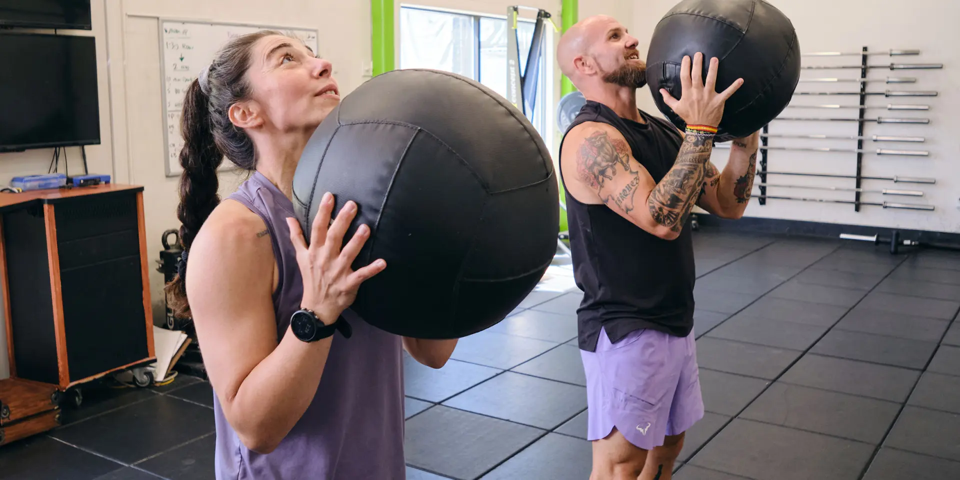 Personal trainer with clients performing medicine ball lifts at the Pleasant Hill YMCA