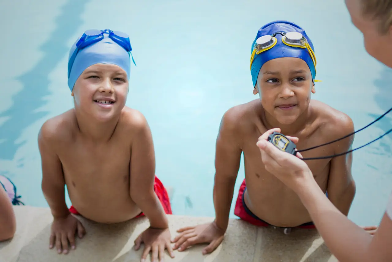 Two kids getting ready to swim in a pool