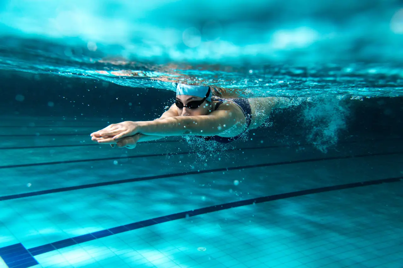 adult female doing underwater laps in indoor pool