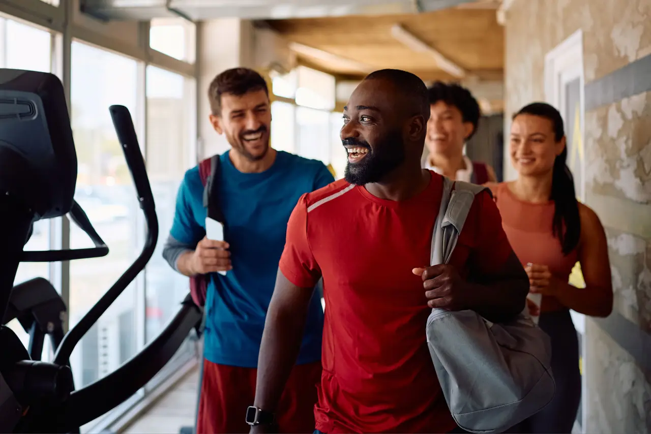 Diverse group of adult members walking out of the cardio room