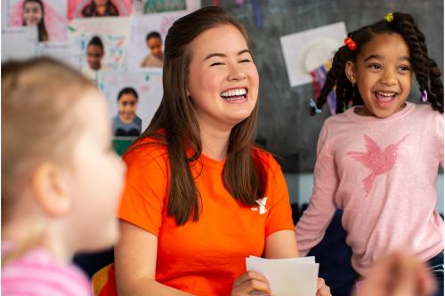 smiling teacher working with two young children