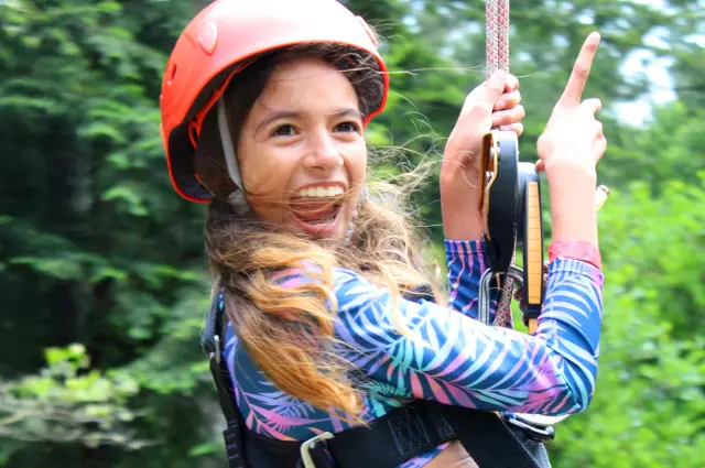 Camp Loma Mar female camper smiling while on the zip line