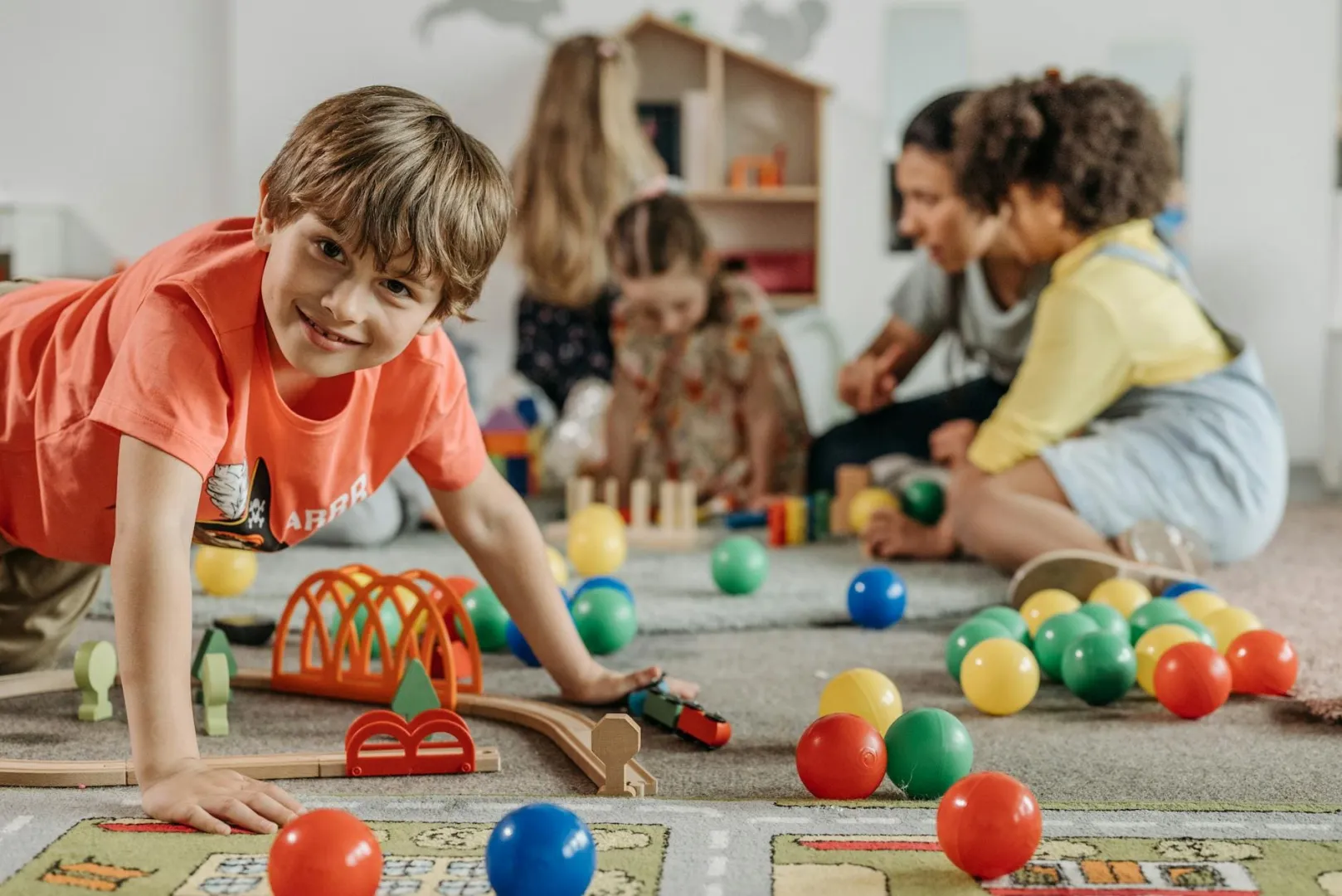 Children playing with colorful toys on the floor.