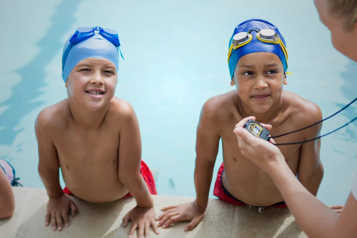Two kids getting ready to swim in a pool