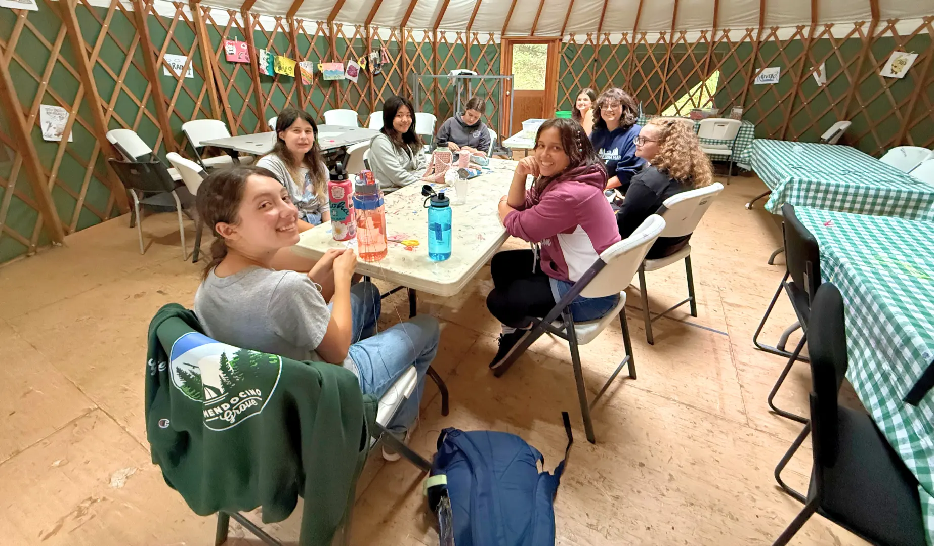 Camp Loma Mar campers sit at a table in the arts and crafts yurt with their counselor.