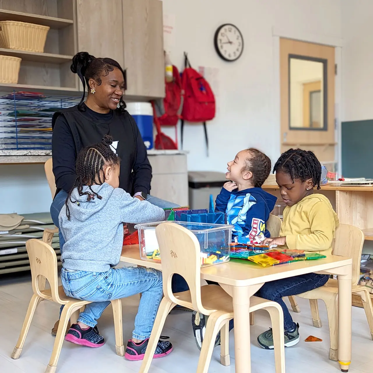 Early Learning Center preschool teacher with a group on student at a classroom table