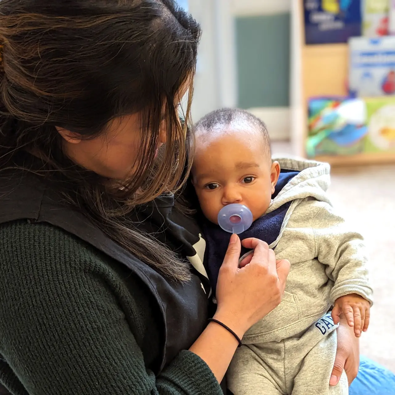 Infant being held and soothed by preschool teacher