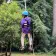 A Camp Loma Mar camper rides the zip line with their back to the camera in a blue hoodie.