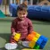 Early Learning Center male toddler playing with blocks on outdoor playground