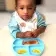 Infant female in highchair enjoying breakfast 