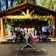 A group of adults and children standing on the Camp Loma Mar Campfire Bowl stage smiling and enjoying the redwood forest.
