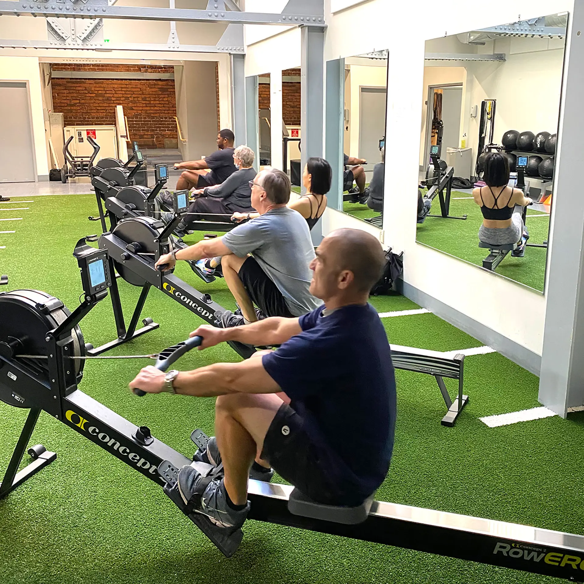 Berkeley members taking a Rowfit group exercise class in the fucntional fitness area