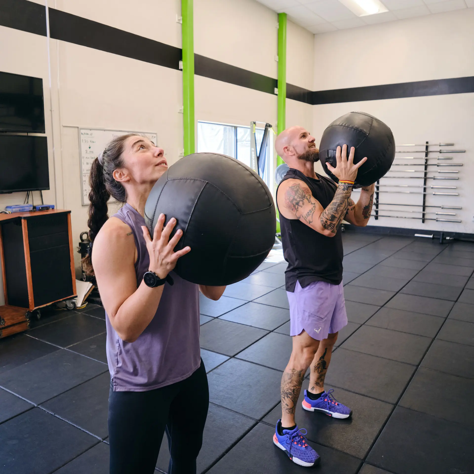 Personal trainer with clients performing medicine ball lifts at the Pleasant Hill YMCA