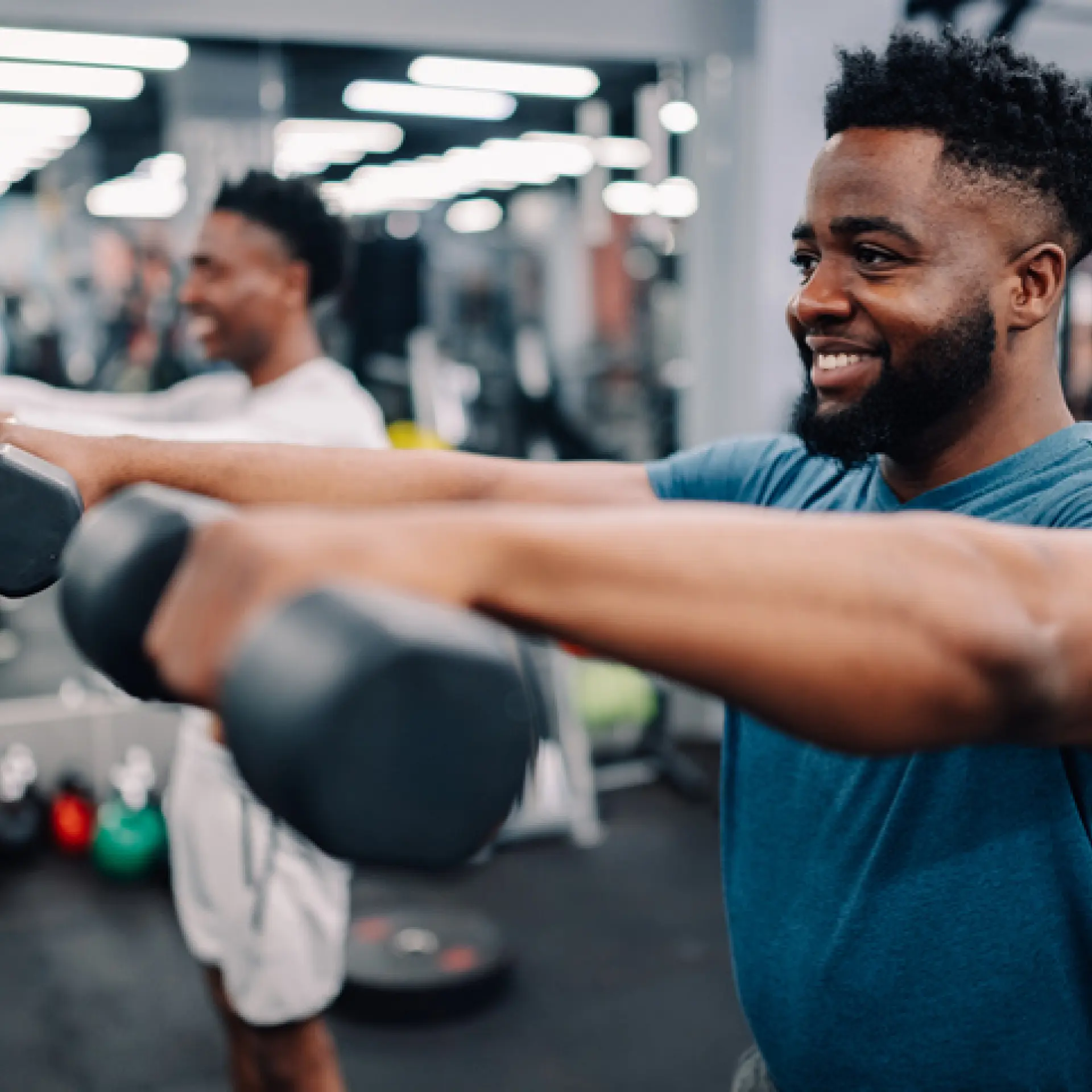 Two young adult men listing hand weights