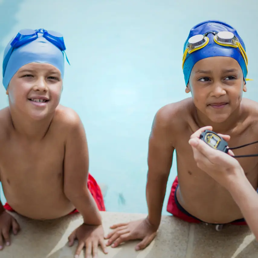 Two kids getting ready to swim in a pool
